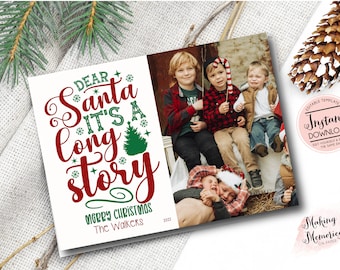 May include: A Christmas card with the text "Dear Santa It's a Long Story" in red and green. The card includes a family photo and the words "Merry Christmas" and "The Walkers 2023". A pine cone and evergreen sprig are in the background.