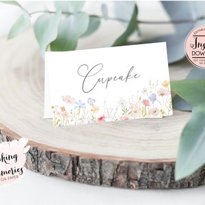 Pu&ograve; includere: Carta da tavolo da matrimonio stampabile con un bordo floreale e la parola "Cupcake" in corsivo. La carta &egrave; bianca con un design floreale ad acquerello in tonalit&agrave; rosa, blu e giallo.
