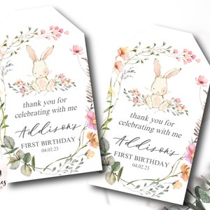 May include: Two printable thank you tags featuring a watercolor illustration of a bunny rabbit surrounded by flowers. The text reads "thank you for celebrating with me Addison's First Birthday 04.02.23".