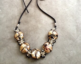 gold & black swirled glass beads on a leather cord, necklace and earrings