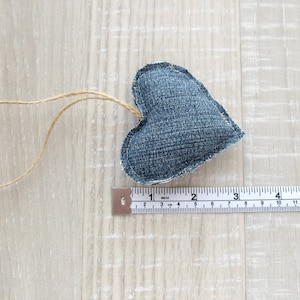 Puede incluir: Un adorno en forma de coraz&oacute;n de mezclilla azul con un lazo de cuerda para colgar. El coraz&oacute;n mide aproximadamente 5 cm de ancho.