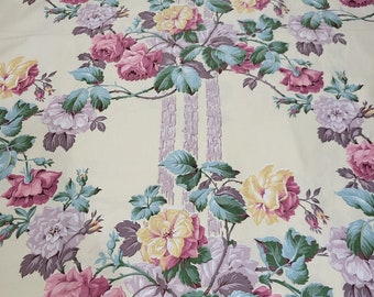May include: A yellow fabric with a floral pattern featuring pink, yellow, and blue roses. The fabric has a vertical stripe pattern in a light purple color.