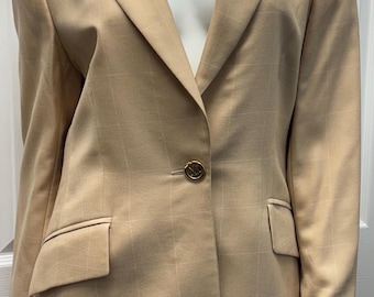 May include: Tan blazer with a subtle plaid pattern. The blazer features a single-button closure, notched lapels, and two front pockets. The gold-colored button adds a touch of elegance to the tailored design. The blazer is displayed on a mannequin.