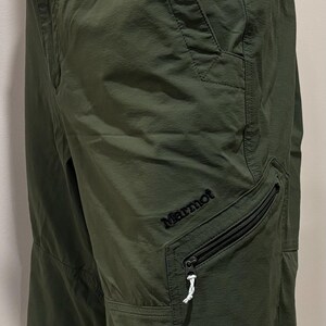 May include: Green cargo shorts with a zippered pocket and the Marmot logo on the right leg.