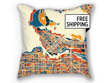 May include: Square throw pillow with a colorful map design. The map features a city layout in shades of blue, orange, and red, set against a cream background. The pillow has the words "FREE SHIPPING" in a black rectangle.