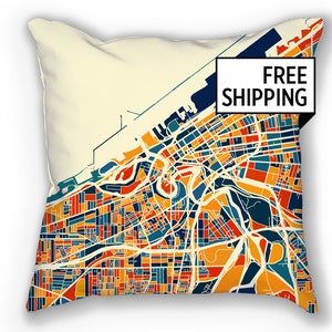 May include: A throw pillow featuring a colorful map of Cleveland, Ohio. The map is in a retro style with a cream background and bright colors. The pillow is a great way to show your city pride.