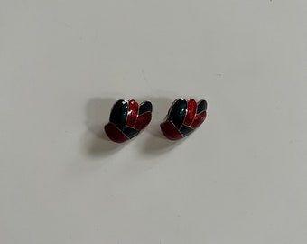May include: A pair of stud earrings featuring a segmented, curved design. Each earring is composed of interlocking sections of glossy black, deep teal, and vibrant red enamel, all outlined with thin, polished silver-toned metal borders.
