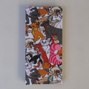 May include: Rectangular fabric item featuring a colorful pattern of cartoon cats on a white background. The design includes various cat characters in different poses and colors, creating a playful and whimsical aesthetic. The item is likely a decorative piece or a fabric panel.