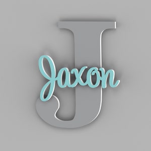 May include: A gray wooden letter J with the name "Jaxon" written in light blue on it.