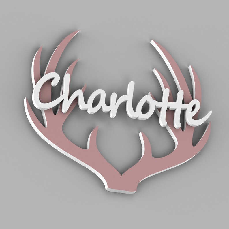 May include: A decorative wall hanging featuring the name "Charlotte" in white script, set against a backdrop of pink antlers. The antlers have a white outline, creating a 3D effect. The design is set against a gray background.