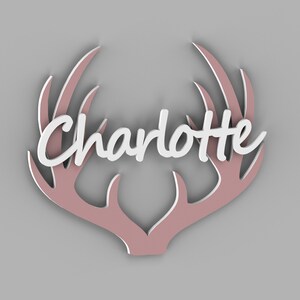 May include: A decorative wall hanging featuring the name "Charlotte" in white script, set against a pink antler design. The antlers have a layered effect, creating depth. The piece is likely made of wood or a similar material.