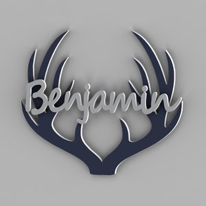 May include: A silver name sign with the name "Benjamin" in a cursive font, mounted on a dark blue wooden antler silhouette.