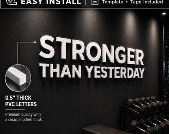May include: White PVC letters spelling "STRONGER THAN YESTERDAY" on a black wall. The letters are 0.5 inches thick and have a clean, modern finish. The image also includes text that says "EASY INSTALL" and "Template + Tape Included".