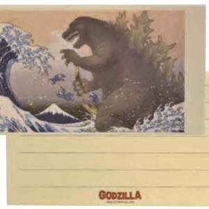 May include: Stationery set featuring a Godzilla-themed design. The artwork depicts Godzilla in a parody of Hokusai's "The Great Wave off Kanagawa." The set includes a notepad and an envelope, with the word "GODZILLA" printed at the bottom.