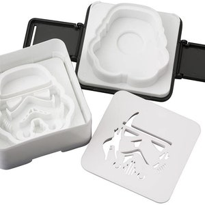 May include: White plastic molds for making Star Wars themed sandwiches. The molds feature the iconic Stormtrooper helmet design.