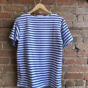 May include: A white and blue striped short-sleeved t-shirt with a small white label that says "Armor Lux" on the front.