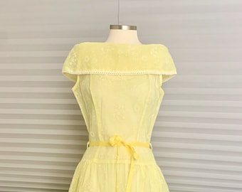 May include: A yellow sleeveless dress with a white lace trim on the neckline and a yellow ribbon tied at the waist.