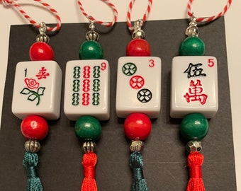 May include: Four red and green Chinese mahjong tile ornaments with tassels. The tiles are numbered 1, 9, 3, and 5. The tiles have Chinese characters and symbols on them.