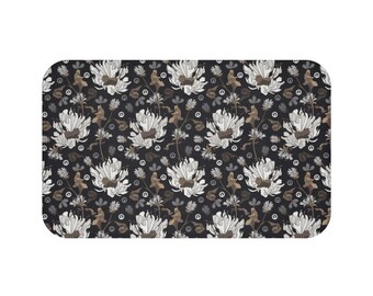 Könnte beinhalten: Eine schwarze Badematte mit einem weißen Blumenmuster. Die Blumen sind stilisiert und haben einen Vintage-Look. Der Hintergrund ist dunkel anthrazitfarben.