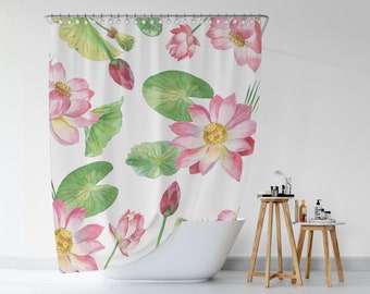 Puede incluir: Cortina de ducha blanca con un diseño de acuarela de flores de loto rosas, hojas de nenúfar verdes y capullos. El patrón floral se repite en la tela. La cortina cuelga frente a una bañera blanca.