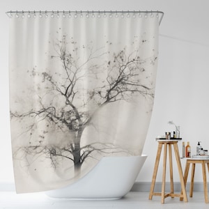 May include: A white shower curtain with a black and white silhouette of a tree in a foggy setting.