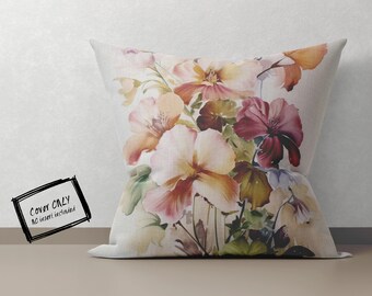 May include: A decorative pillow cover with a floral design featuring watercolor-style pink, red, and yellow flowers on a white background.