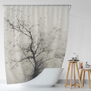 May include: A black and white shower curtain featuring a watercolor-style image of a tree with branches reaching towards the sky. The background is a light gray color.