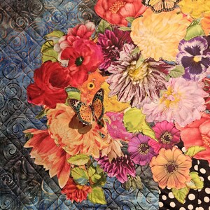 Puede incluir: Una tela floral colorida con una variedad de flores, incluyendo rojas, rosas, amarillas y moradas. La tela presenta una mariposa en el centro y un patr&oacute;n de lunares negros y blancos en el fondo.
