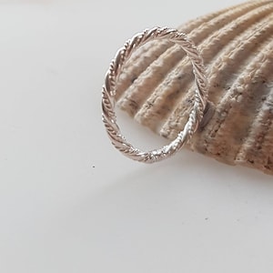 Peut inclure: Une bague en argent avec un design de corde torsadée.