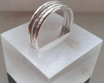 May include: A set of four silver stacking rings with a hammered texture.