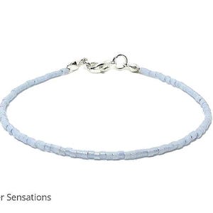 May include: A delicate light blue beaded bracelet with a silver clasp.