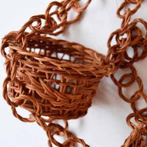 May include: A brown woven hanging basket with a braided rope handle.