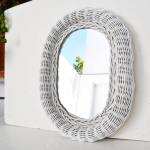 White decorative mirror with braided wicker frame