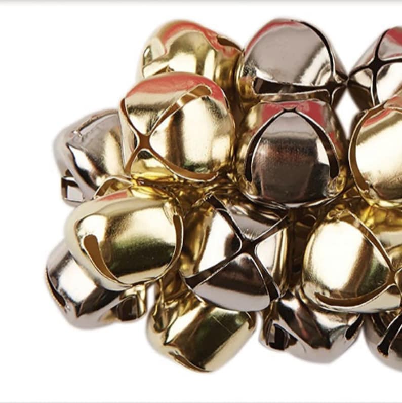 May include: A pile of gold and silver jingle bells. The bells are small and have a classic design.