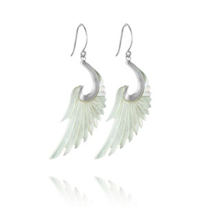 May include: A pair of silver earrings with white mother-of-pearl wings. The wings are detailed with delicate lines and have a slightly curved shape.