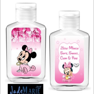 May include: Two clear plastic bottles of hand sanitizer with pink and white labels featuring a cartoon image of Minnie Mouse. The labels read "Little Miracle Soft, Sweet, Clean & Pure".