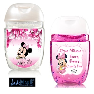 May include: Two clear plastic bottles of hand sanitizer with pink labels featuring a cartoon image of Minnie Mouse. The labels read "Little Miracle Soft, Sweet, Clean & Pure".