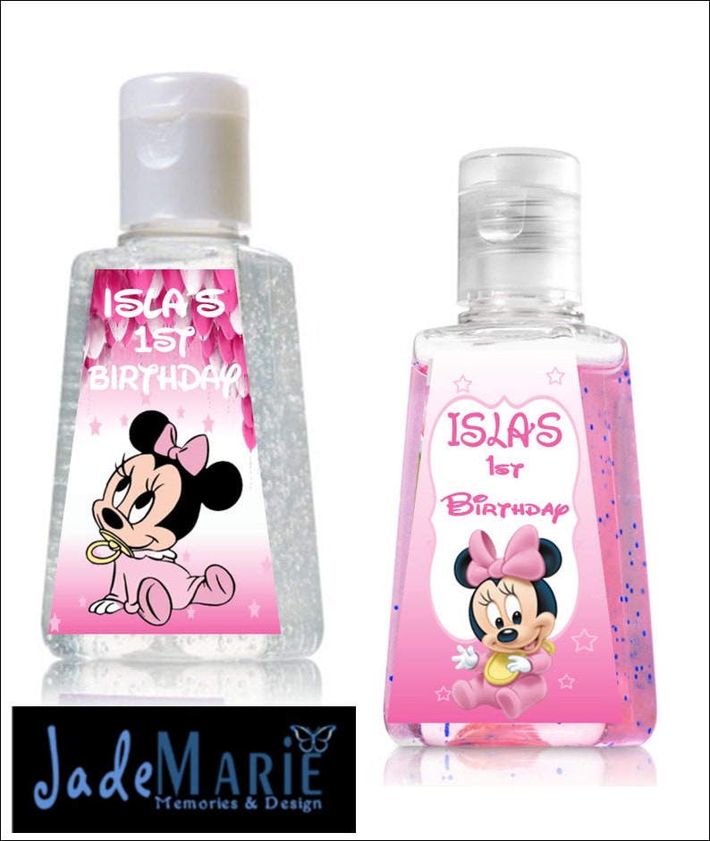 May include: Two clear plastic bottles of hand sanitizer with pink and white labels featuring a cartoon image of Minnie Mouse. The labels also include the text "Isla's 1st Birthday".