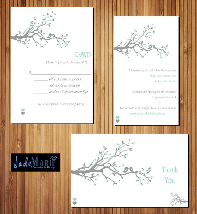 May include: RSVP card with a gray branch with green leaves and two birds. The card has a white background and the text "RSVP" in black. The text "Please reply by September 30, 2015" is also in black. The card has a line for the guest to indicate if they will celebrate in person, in spirit, or the number of guests attending. The card also has a small green heart at the bottom.