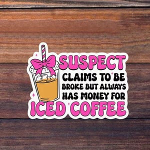 May include: A die-cut sticker featuring an illustration of an iced coffee in a clear plastic cup with a pink bow on the straw. The text reads: SUSPECT CLAIMS TO BE BROKE BUT ALWAYS HAS MONEY FOR ICED COFFEE in bold pink and black lettering.