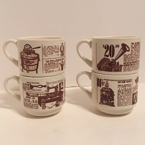 Könnte beinhalten: Set aus vier weißen Keramikbechern mit braunen Vintage-Anzeigen, die darauf gedruckt sind. Die Anzeigen zeigen Bilder einer Waschmaschine, einer Nähmaschine, eines Grammophons und eines Holzofens. Der Text auf den Bechern enthält Preise und Produktbeschreibungen.