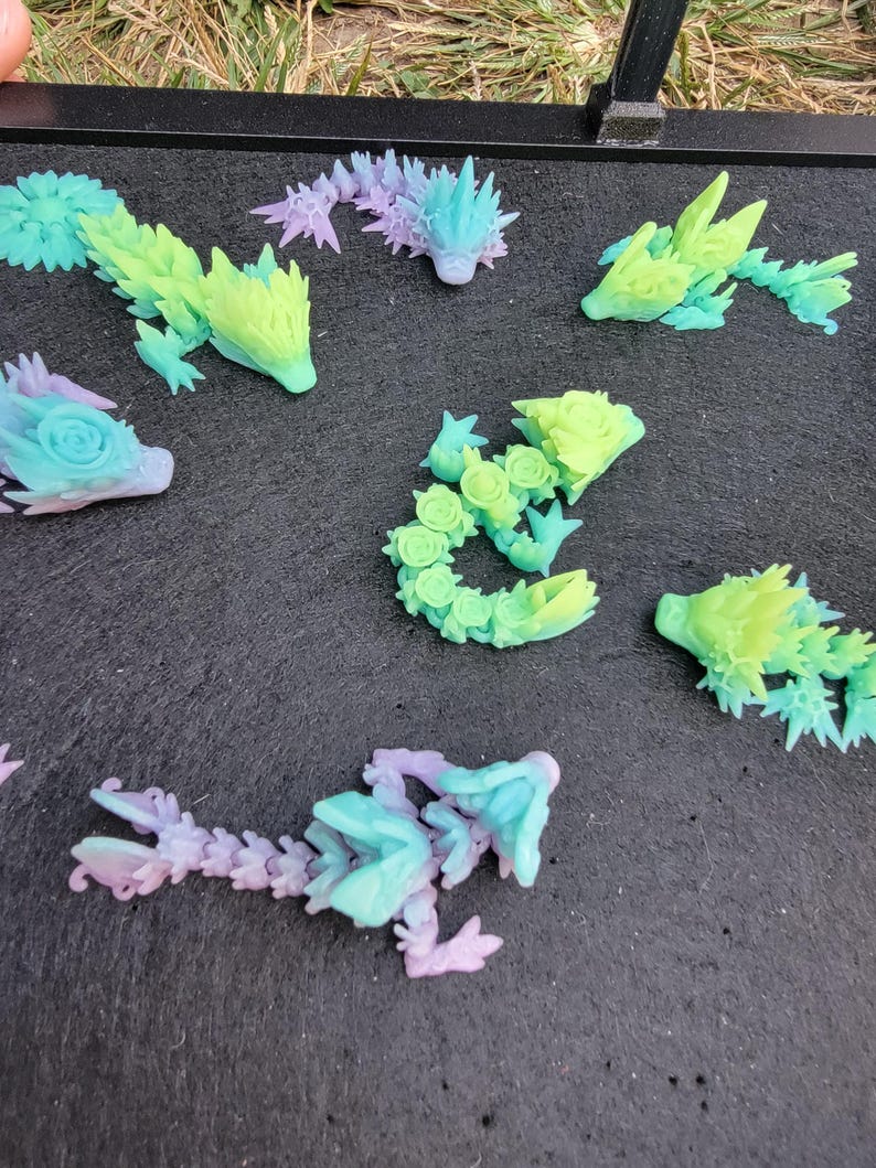 Pu&ograve; includere: Una collezione di sette piccole figurine di creature fantastiche stampate in 3D e colorate. Le figurine sono realizzate in plastica trasparente e presentano una variet&agrave; di colori, tra cui verde, blu, viola e rosa.