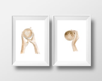 May include: Two framed watercolor illustrations of hands holding a coffee cup with a heart design in the foam. The coffee cup is brown and white.