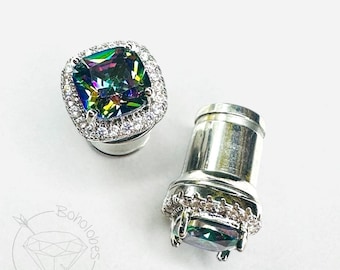 May include: A pair of silver-toned ear plugs featuring a square-cut iridescent stone surrounded by a halo of small clear crystals. The plugs have a cylindrical body and a flat front face. A logo with the text Boholobes is visible.
