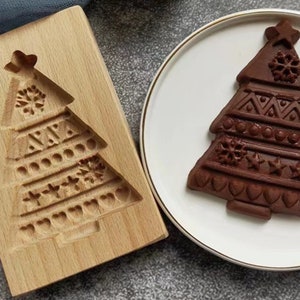 May include: A wooden Christmas tree mold with a detailed design of snowflakes, stars, and hearts. A chocolate Christmas tree made with the mold is shown on a white plate.