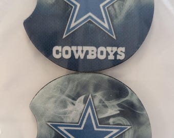 May include: Two round, blue and white, fabric drink coasters with a white star and the word "COWBOYS" printed on them.