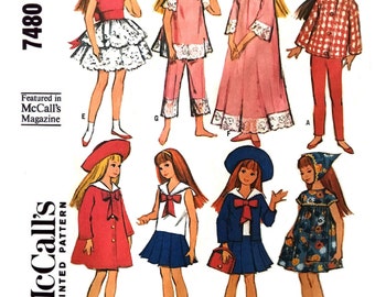 May include: A vintage sewing pattern for making doll clothes. The pattern includes instructions for making a variety of outfits, including a dress, a skirt and top, a nightgown, a coat, a sailor outfit, and a dress with a floral print. The pattern is for a 9-inch doll.