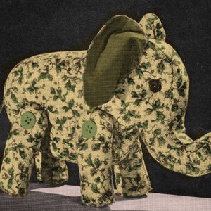 May include: A plush toy elephant with a green floral pattern. The elephant has a large green ear and two green buttons on its body.