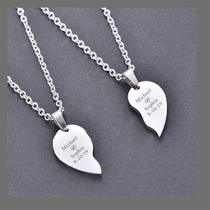 May include: Two silver necklaces with matching heart-shaped pendants. Each pendant is engraved with the names "Michael" and "Sophia" and the date "8-10-19".