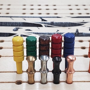 May include: A set of 18 colorful wooden pegs with different colored tops, including blue, red, green, yellow, orange, brown, black, white, and silver. The pegs are arranged in a row on a wooden board.
